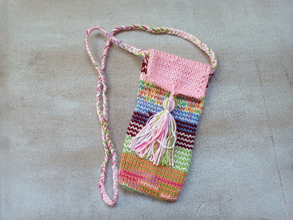 bunte Handytasche, gestrickt aus Garnresten und mit Quaste als Verschluss