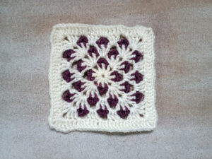 zweifarbiges Granny Square mit Blattmuster in Weiß und Lila