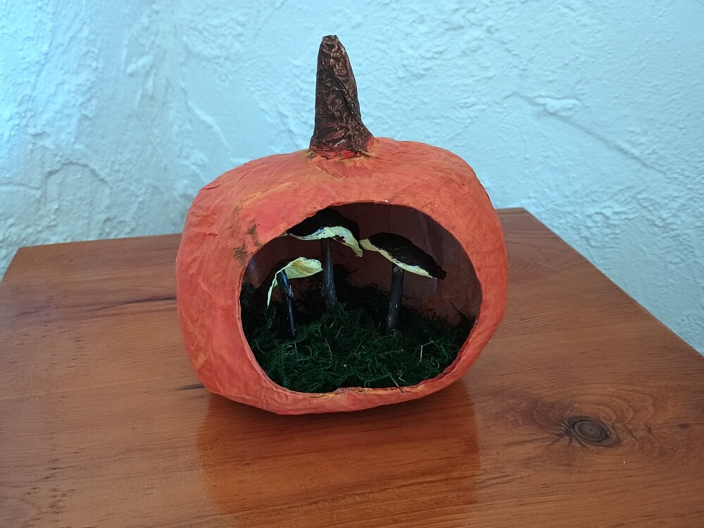 Kürbis mit Moos und Pilzen als Herbstdeko