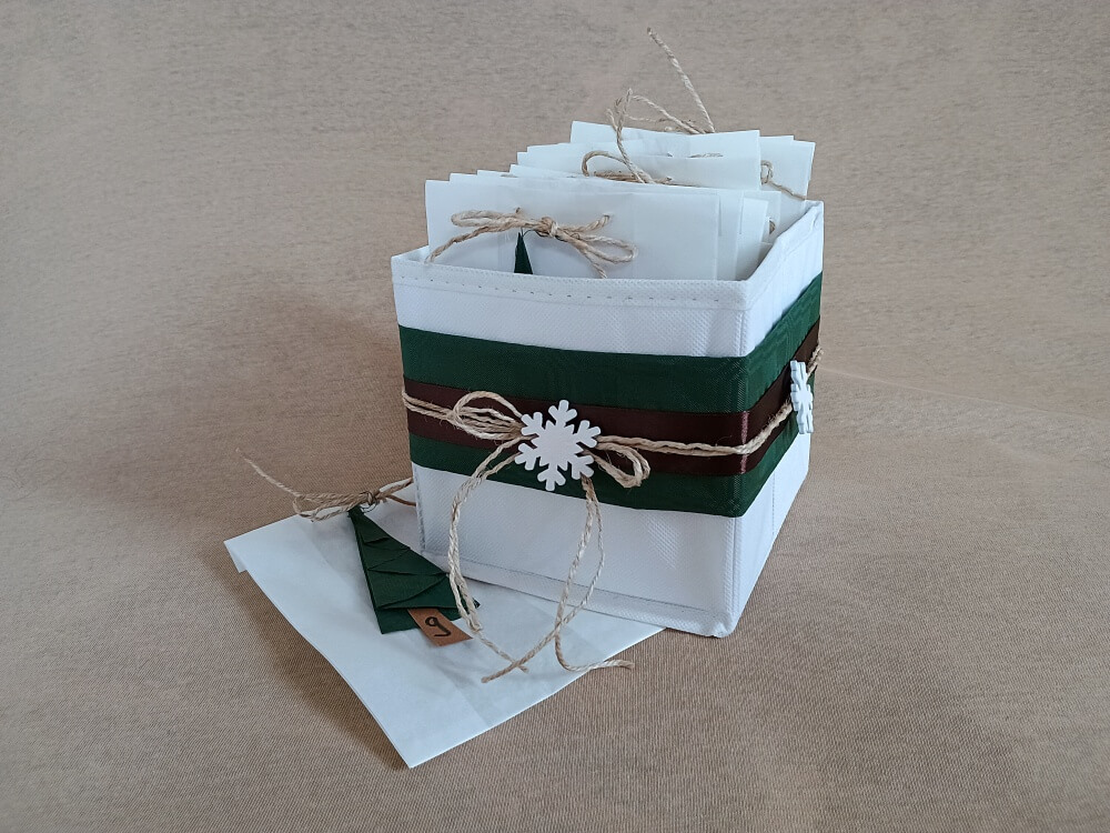 DIY-Adventskalender aus Stoffbox, Tüten und gefalteten Tannenbäumen, verziert mit einer Banderole