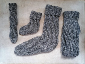 Gestrickte Spiralsocken in zwei Größen aus grau meliertem Garn