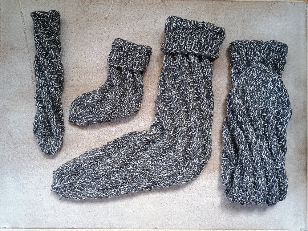 Gestrickte Spiralsocken in zwei Größen aus grau meliertem Garn