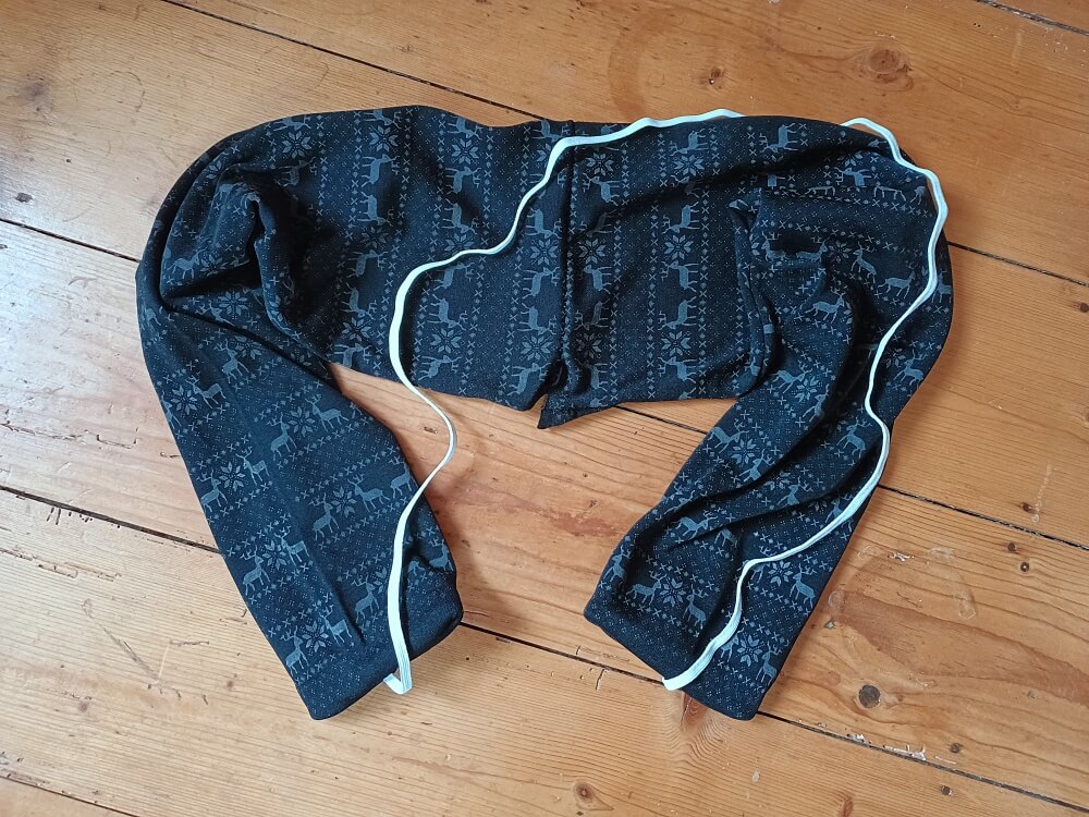 Hose zum Zugluftstopper zusammengenäht, mit Gummiband als Halterung außen